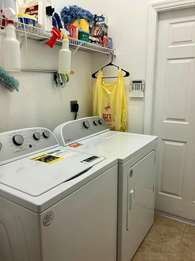 clothes washing area featuring light tile patterned flooring and washer and clothes dryer