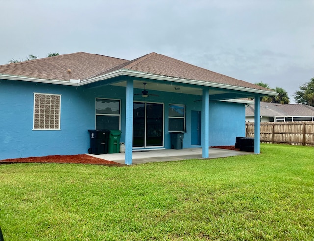 back of property with ceiling fan, a lawn, and a patio area