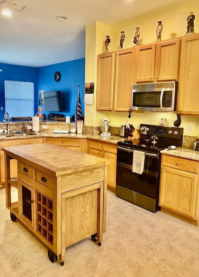 kitchen featuring light brown cabinetry, black electric range, sink, and kitchen peninsula