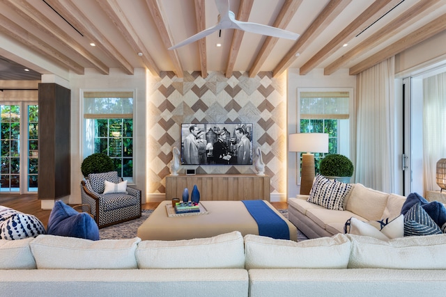 living room with a wealth of natural light, beamed ceiling, wood-type flooring, and ceiling fan