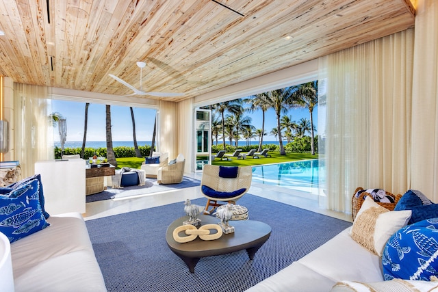 living room with concrete flooring, a water view, and wooden ceiling