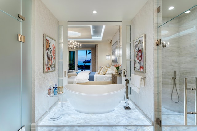 bathroom with shower with separate bathtub, a notable chandelier, and a raised ceiling