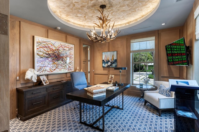 carpeted office space featuring a notable chandelier and a raised ceiling