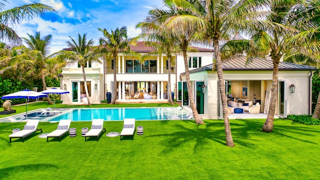 back of property with a patio, a lawn, and a balcony