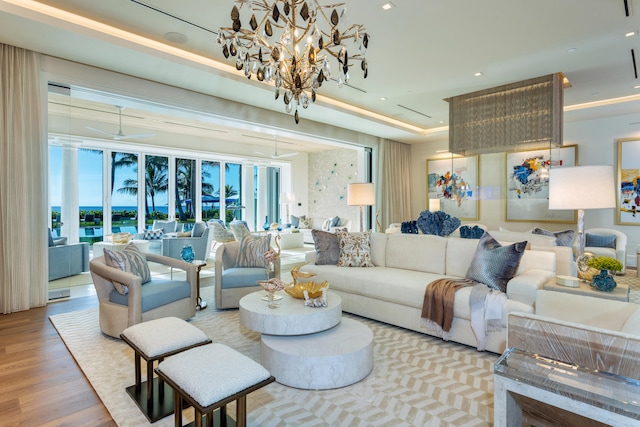 living room with light hardwood / wood-style flooring, a chandelier, and a tray ceiling