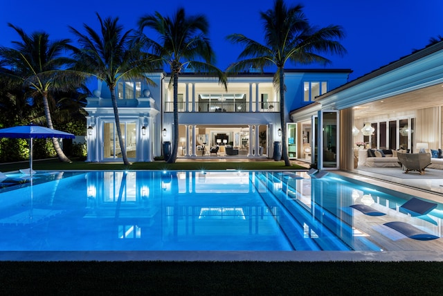 pool at night with an outdoor living space