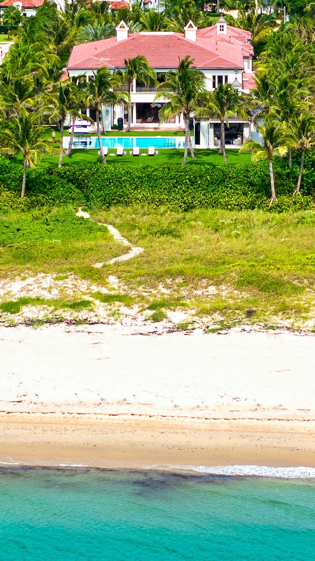 view of pool with a water view and a beach view