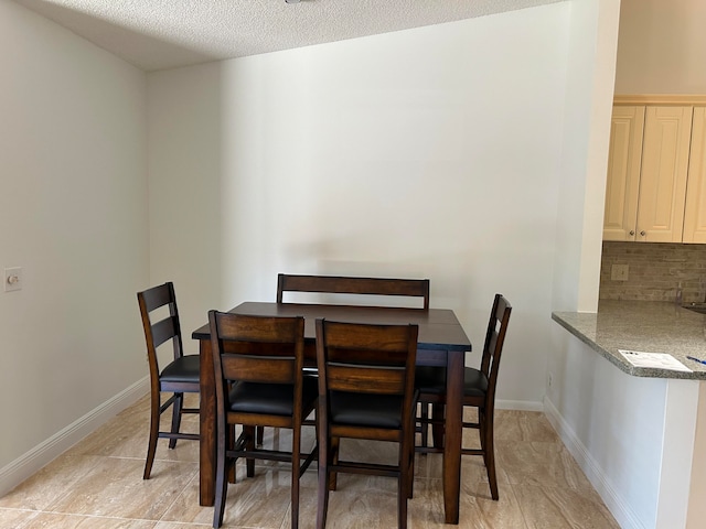 dining space featuring a textured ceiling