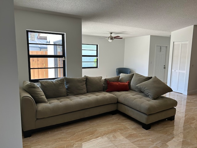 living room with ceiling fan and a textured ceiling