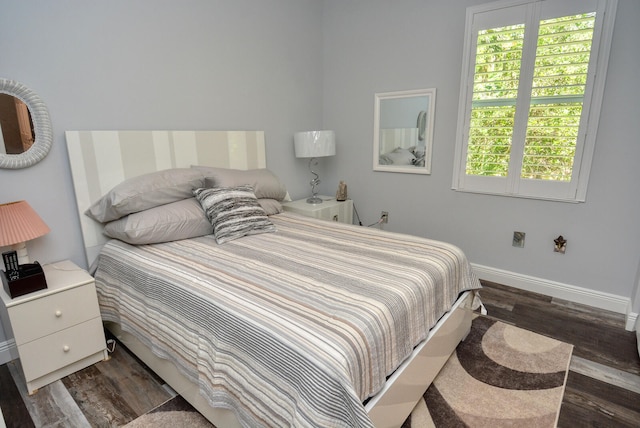 bedroom with dark hardwood / wood-style flooring