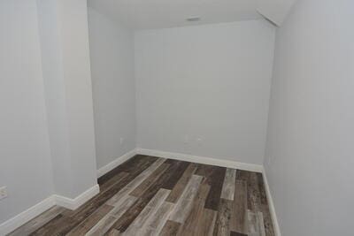 unfurnished room with dark wood-type flooring