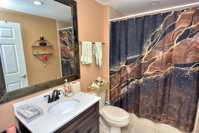 bathroom featuring vanity, a textured ceiling, and toilet