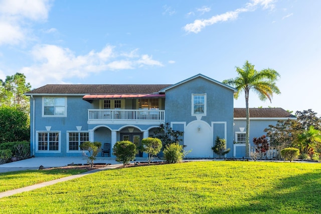 view of front of property with a balcony and a front lawn