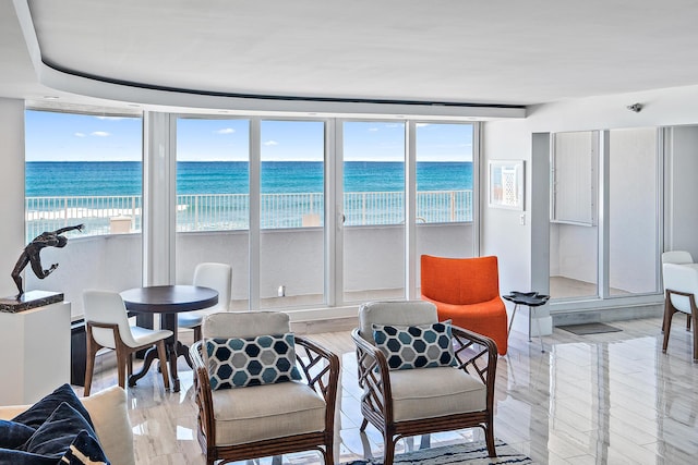 interior space with a water view, a beach view, and light hardwood / wood-style flooring