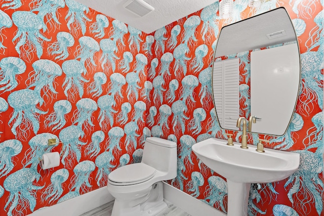 bathroom with a textured ceiling and toilet