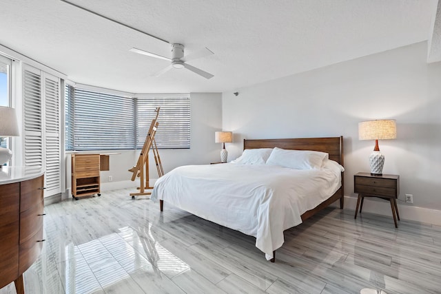 bedroom featuring ceiling fan, a textured ceiling, and light hardwood / wood-style flooring