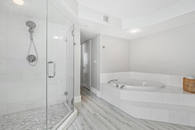 bathroom featuring shower with separate bathtub and hardwood / wood-style floors