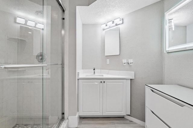 bathroom featuring vanity, a textured ceiling, and an enclosed shower