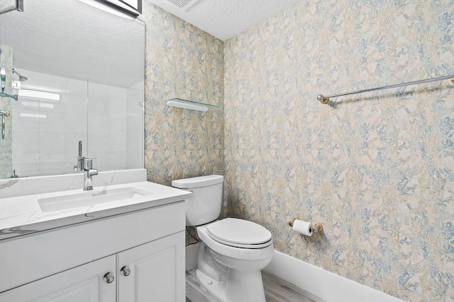 bathroom with a textured ceiling, toilet, hardwood / wood-style floors, and vanity