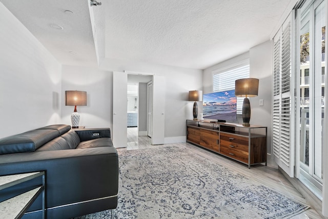 living room with light hardwood / wood-style floors and a textured ceiling