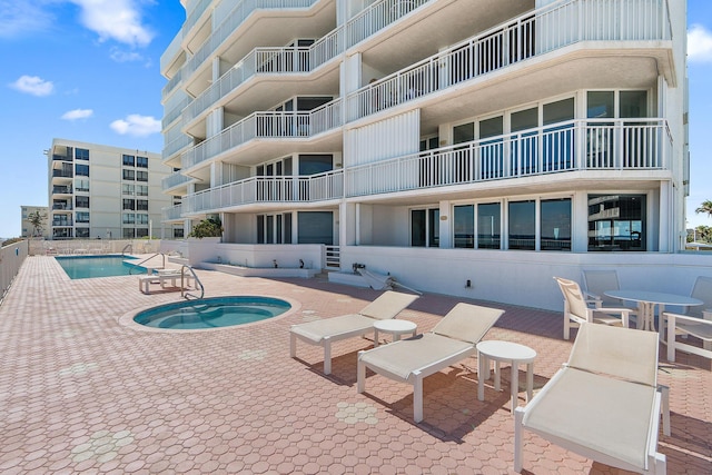 view of pool featuring a hot tub and a patio