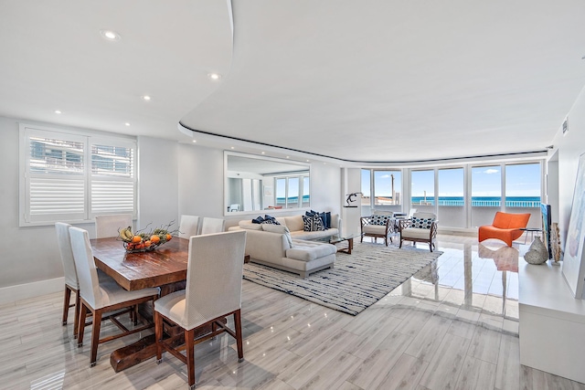 dining area with floor to ceiling windows and light hardwood / wood-style floors