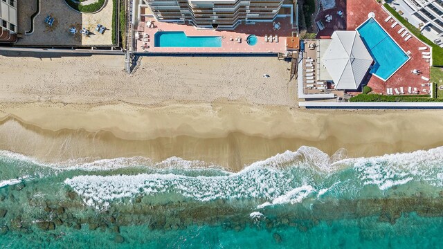 drone / aerial view with a water view and a beach view