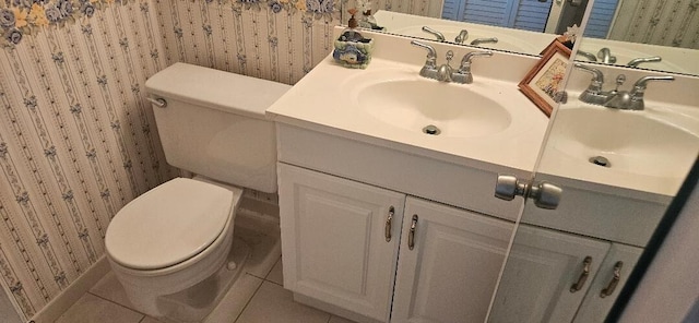 bathroom with toilet, vanity, and tile patterned floors