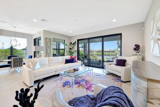 tiled living room with a water view and a chandelier