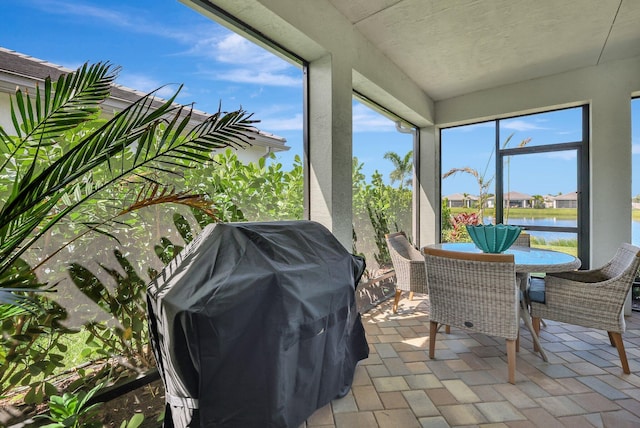 sunroom featuring a water view