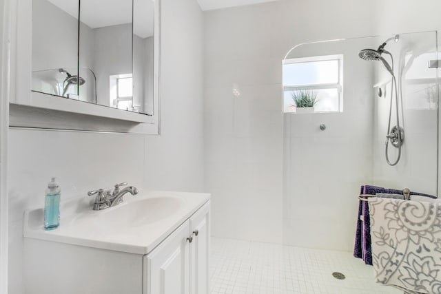 bathroom with a tile shower, tile patterned floors, and vanity