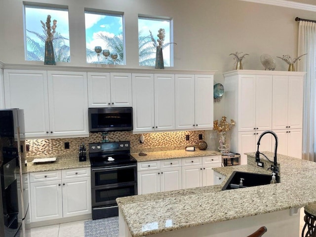 kitchen with white cabinetry, black electric range, refrigerator, and sink