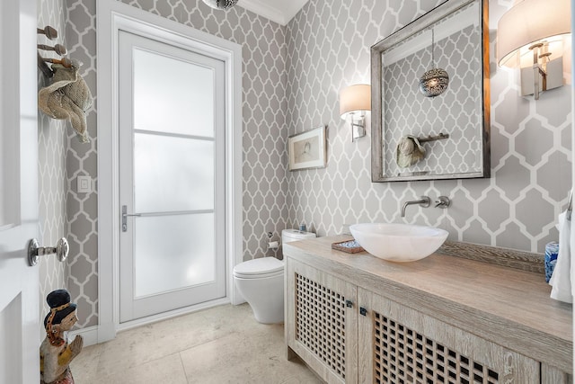 bathroom with toilet, vanity, tile patterned flooring, and crown molding