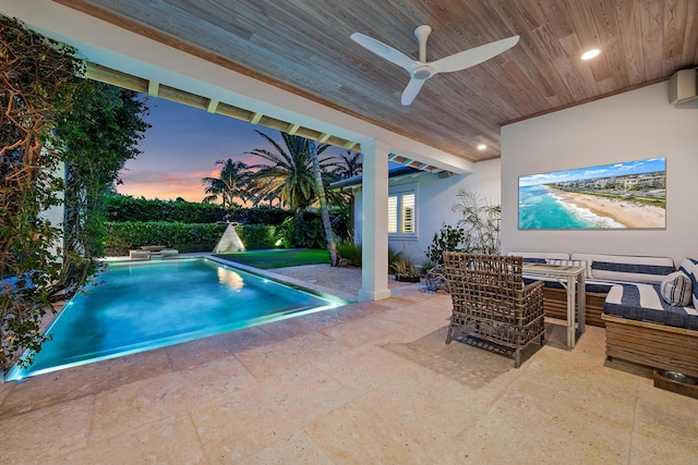 pool at dusk with a patio area, outdoor lounge area, and ceiling fan