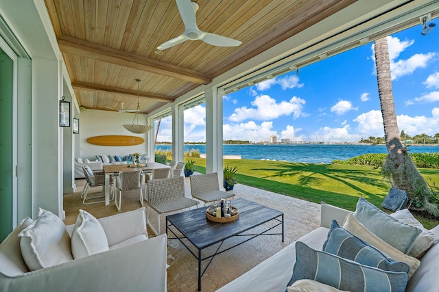 view of patio / terrace with ceiling fan, an outdoor living space, and a water view