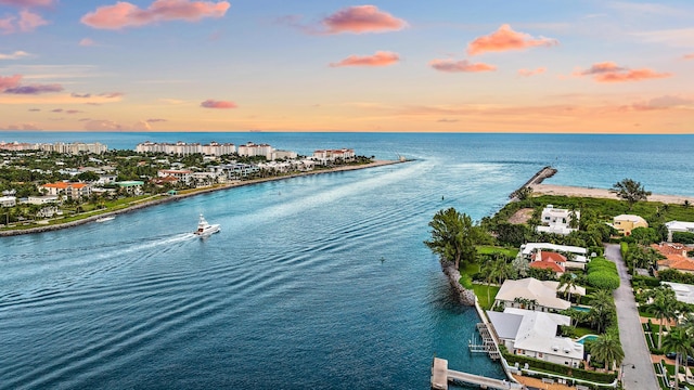 aerial view at dusk featuring a water view