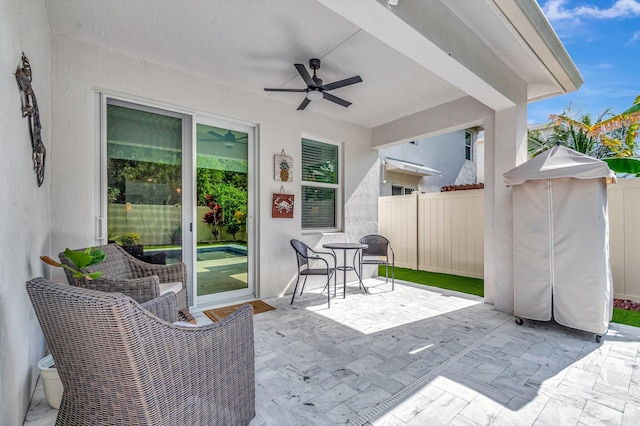 view of patio featuring a ceiling fan and fence