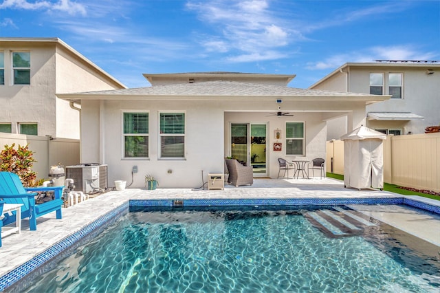 back of property with a fenced backyard, a ceiling fan, and a patio area