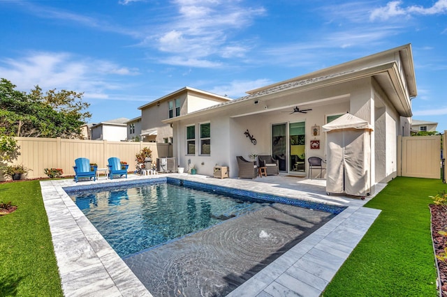rear view of house with a fenced backyard, ceiling fan, a patio area, and stucco siding