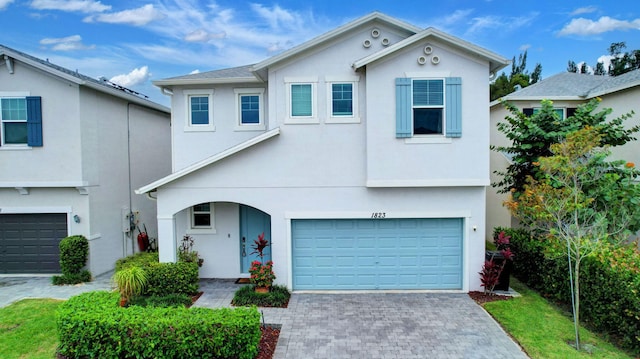 view of front of house featuring a garage, stucco siding, and decorative driveway