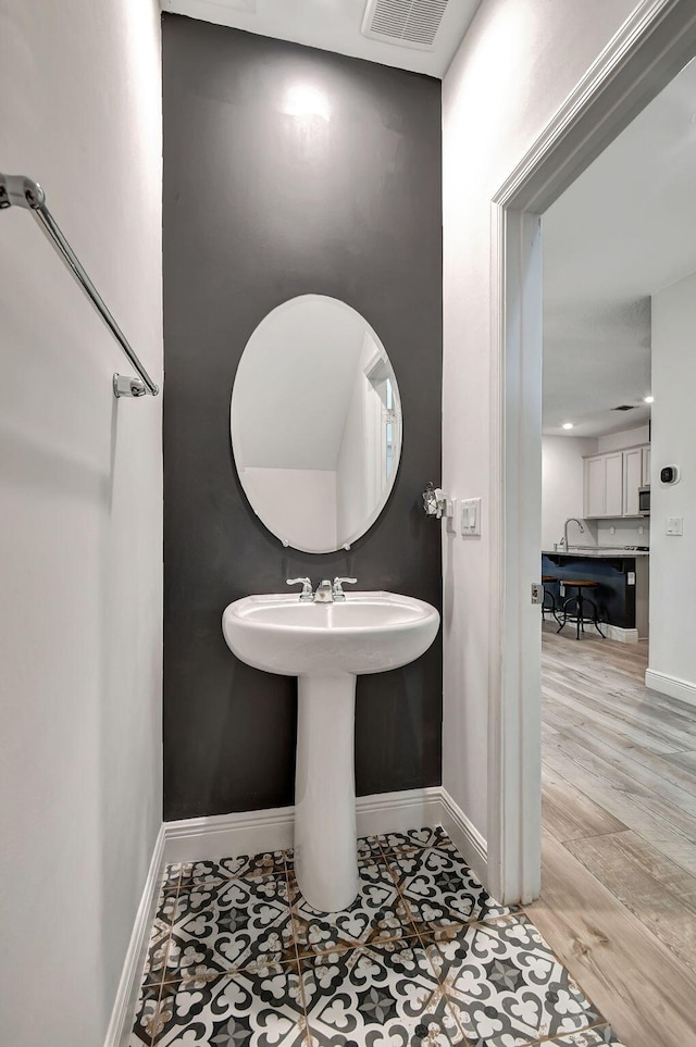 bathroom featuring baseboards, visible vents, and wood finished floors