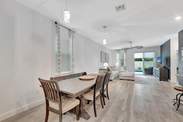 dining area with visible vents, a ceiling fan, baseboards, and light wood-type flooring