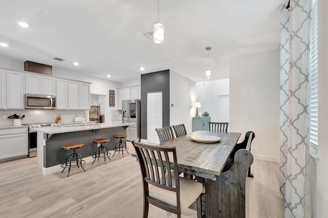 dining area featuring recessed lighting, baseboards, visible vents, and light wood finished floors