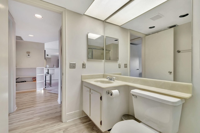 bathroom featuring hardwood / wood-style flooring, vanity, and toilet