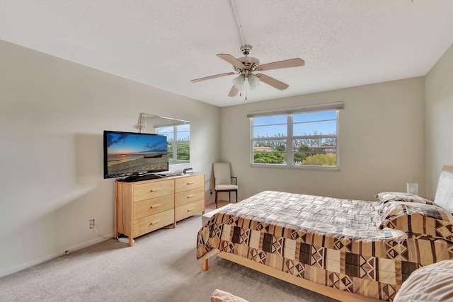 carpeted bedroom with ceiling fan and a textured ceiling