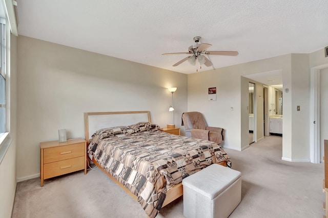 carpeted bedroom featuring ensuite bath, ceiling fan, and a textured ceiling