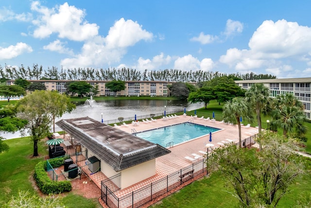 view of pool with a lawn and a water view