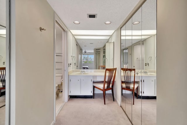 bathroom featuring ceiling fan, vanity, a textured ceiling, and toilet