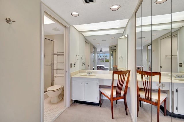 bathroom with toilet, vanity, a textured ceiling, and walk in shower