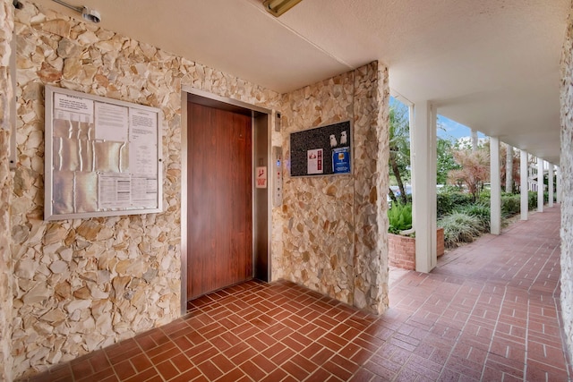 interior space featuring a textured ceiling and elevator